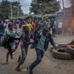 
              Supporters of presidential candidate Raila Odinga run past a roadblock of burning tires in the Kibera neighborhood of Nairobi, Kenya Monday, Aug. 15, 2022. After last-minute chaos that could foreshadow a court challenge, Kenya's electoral commission chairman has declared Deputy President William Ruto the winner of the close presidential election over five-time contender Raila Odinga. (AP Photo/Ben Curtis)
            