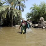
              A woman wades through a flooded area after heavy rains in the Shikarpur district of Sindh province, Pakistan, Tuesday, Aug. 30, 2022. Disaster officials say nearly a half million people in Pakistan are crowded into camps after losing their homes in widespread flooding caused by unprecedented monsoon rains in recent weeks. (AP Photo/Fareed Khan)
            