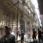 
              Police officers and workers are seen at the site of the Abu Sefein church under scaffolds, a day after a fire killed over 40 people and injured at least 14 others, in the densely populated neighborhood of Imbaba, in Cairo, Egypt, Monday, Aug. 15, 2022. (AP Photo/Amr Nabil)
            