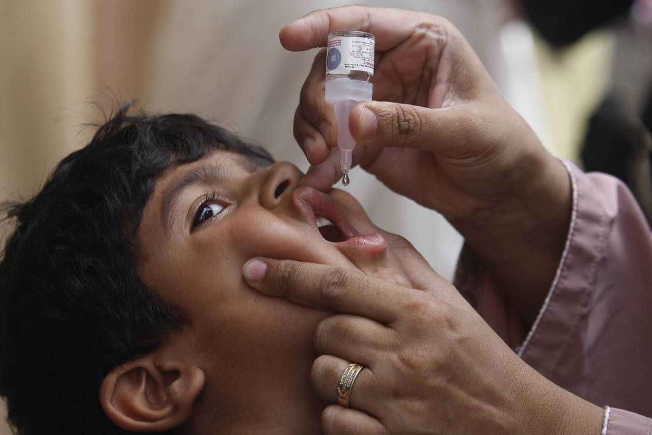 FILE - A health worker gives a polio vaccine to a child in Karachi, Pakistan, May 23, 2022. British...