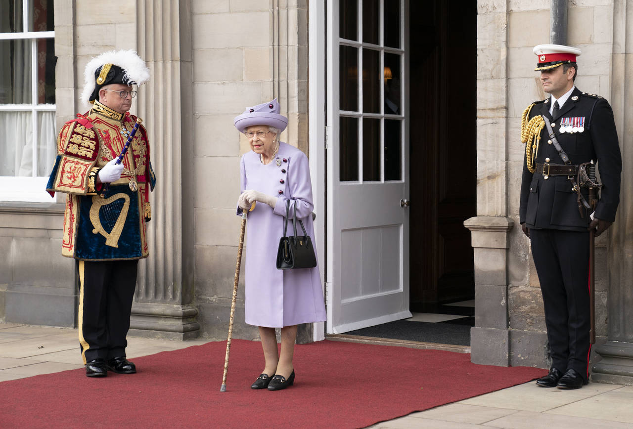 FILE - Queen Elizabeth II attends an armed forces act of loyalty parade in the gardens of the Palac...