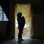 
              FILE - Michelle Flandez stands in her home with her two-month-old son Inti Perez, woh is diagnosed with microcephaly linked to the mosquito-borne Zika virus, in Bayamon, Puerto Rico on Dec. 16, 2016. Climate hazards such as flooding, heat waves and drought have worsened more than half of the hundreds of known infectious diseases in people, such as zika, dengue, hantavirus, cholera and even anthrax, according to a new study released Monday, Aug. 8, 2022. (AP Photo/Carlos Giusti, File)
            