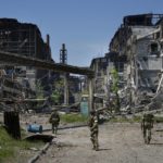
              FILE - Russian soldiers patrol an area of the Metallurgical Combine Azovstal, in Mariupol, on the territory which is under the Government of the Donetsk People's Republic control, eastern Ukraine, on June 13, 2022. Despite getting bogged down in Ukraine, the Kremlin has resisted announcing a full-blown mobilization, a move that could prove to be very unpopular for President Vladimir Putin. That has led instead to a covert recruitment effort that includes trying to get prisoners to make up for the manpower shortage. (AP Photo, File)
            