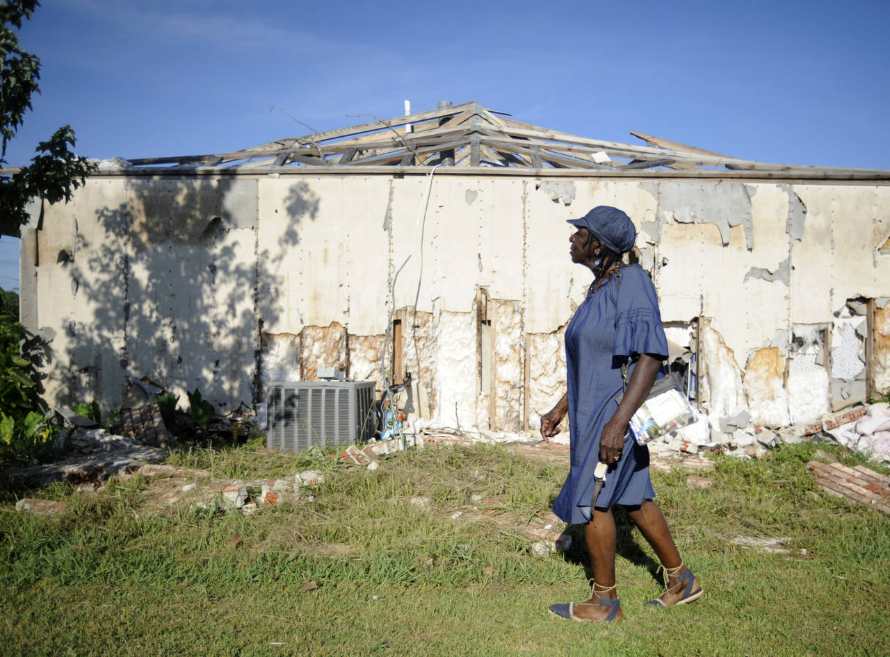 Eula Dell Lanier walks past her storm-damaged home, Wednesday, July 27, 2022, nearly four months af...
