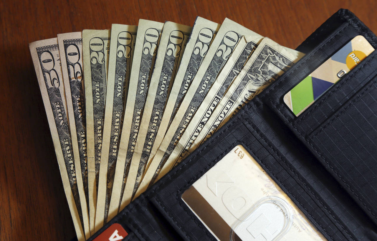FILE - In this June 15, 2018, file photo, cash is fanned out from a wallet in North Andover, Mass. ...