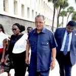 
              Rev. Jesse Jackson escorts Wanda Cooper Jones, second from left, Ahmaud Arbery's mother, into the federal courthouse, Monday, Aug. 8, 2022, in Brunswick, Ga., for the sentencing hearings of the 3 white men convicted of federal hate crimes in the killing of Arbery. (AP Photo/Lewis M. Levine)
            