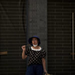 
              A woman eats a sugar-coated Chinese haw in front of vacant shop lots at Qianmen Street in Beijing, Wednesday, Aug. 17, 2022. Factories in China's southwest have shut down after reservoirs used to generate hydropower ran low in a worsening drought, adding to economic strains at a time when President Xi Jinping is trying to extend his position in power. (AP Photo/Andy Wong)
            