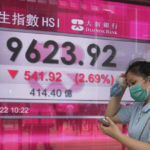
              A woman wearing a face mask walks past a bank's electronic board showing the Hong Kong share index in Hong Kong, Tuesday, Aug. 2, 2022. Asian shares were mostly lower Tuesday amid concerns about regional stability as an expected visit by U.S. House Speaker Nancy Pelosi to Taiwan prompted threats from Beijing. (AP Photo/Kin Cheung)
            