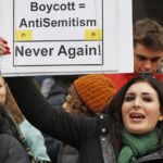 
              FILE - Nationally known far-right activist Laura Loomer holds up a sign across the street from a rally organized by Women's March NYC, Jan. 19, 2019, after she barged onto the stage interrupting Women's March NYC director Agunda Okeyo who was speaking during a rally in New York. Loomer, who's been banned by several social media platforms because of anti-Muslim and other remarks, is challenging incumbent Republican Dan Webster, who has served central Florida districts since 2011. (AP Photo/Kathy Willens, File)
            