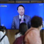 
              People watch a TV screen showing the live broadcast of South Korean President Yoon Suk Yeol's press conference, at the Seoul Railway Station in Seoul, South Korea, Wednesday, Aug. 17, 2022. Yoon said Wednesday his government has no plans to pursue its own nuclear deterrent in the face of growing North Korean nuclear threats, as he urged the North to return to dialogue aimed at exchanging denuclearization steps for economic benefits. (AP Photo/Lee Jin-man)
            