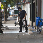 
              A fireman cleans blood off the sidewalk, Sunday, Aug. 7, 2022, in Cincinnati, following an overnight shooting. At least nine people were wounded — none critically — in a shooting outside a Cincinnati bar early Sunday, police said. (Liz Dufour/The Cincinnati Enquirer via AP)
            