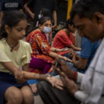 
              A woman wearing a mask as a precaution against coronavirus gets her hands decorated with henna on the eve of the Hindu festival of Raksha Bandhan in New Delhi, India, Thursday, Aug. 11, 2022. The Indian capital reintroduced public mask mandates on Thursday as COVID-19 cases continue to rise across the country. (AP Photo/Altaf Qadri)
            