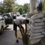 
              Sandbags fortify a gas pump as a queue forms for customers waiting to fill up their tanks in Kostiantynivka, Donetsk region, eastern Ukraine, Saturday, Aug. 20, 2022. (AP Photo/David Goldman)
            