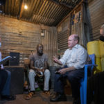 
              Sen. Chris Coons, second right, leading a U.S. congressional delegation, is accompanied by his wife Annie Coons, right, and Rep Dave Joyce, left, as he speaks to patient David Oduor, center, at his home, after visiting the Tabitha Medical Clinic run by CFK Africa in the Kibera neighborhood of Nairobi, Kenya Thursday, Aug. 18, 2022. The delegation also met with current President Uhuru Kenyatta, Kenya's new president-elect William Ruto, and opposition figure Raila Odinga who has said he will challenge his recent election loss in court. (AP Photo/Ben Curtis)
            