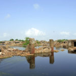 
              Damaged homes are surrounded by floodwaters in Jaffarabad, a district of Pakistan's southwestern Baluchistan province, Sunday, Aug. 28, 2022. Army troops are being deployed in Pakistan's flood affected area for urgent rescue and relief work as flash floods triggered after heavy monsoon rains across most part of the country lashed many districts in all four provinces. (AP Photo/Zahid Hussain)
            