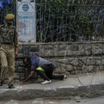 
              A Kashmiri man crosses barbed wire set up by police as a roadblock during restrictions in Srinagar, Indian controlled Kashmir, Sunday, Aug. 7, 2022. Authorities had imposed restrictions in parts of Srinagar, the region's main city, to prevent gatherings marking Muharram from developing into anti-India protests. (AP Photo/Mukhtar Khan)
            