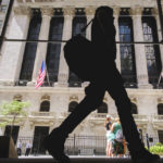 
              A pedestrian walks past the New York Stock Exchange in New York City, Thursday, Aug. 18, 2022. Major indexes were held back by mostly choppy trading following a weeklong run of gains. (AP Photo/J. David Ake)
            