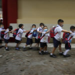 
              Students fall in line during the opening of classes at the San Juan Elementary School in Pasig, Philippines on Monday, Aug. 22, 2022. Millions of students wearing face masks streamed back to grade and high schools across the Philippines Monday in their first in-person classes after two years of coronavirus lockdowns that are feared to have worsened one of the world's most alarming illiteracy rates among children. (AP Photo/Aaron Favila)
            