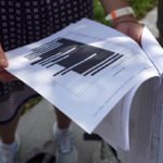 
              Journalists gather outside the Paul S. Rogers Federal Building and U.S. Courthouse in downtown West Palm Beach, Fla., to read a heavily blackout document released by The Justice Department Friday, Aug. 26, 2022.  The 32-page affidavit, even in its heavily redacted form, offers the most detailed description to date of the government records being stored at former President Donald Trump's Mar-a-Lago property long after he left the White House and reveals the gravity of the government's concerns that the documents were there illegally. (AP Photo/Jim Rassol)
            