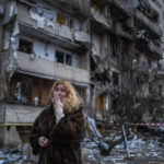 
              FILE - Natali Sevriukova reacts next to her house following a rocket attack the city of Kyiv, Ukraine, Friday, Feb. 25, 2022. (AP Photo/Emilio Morenatti, File)
            