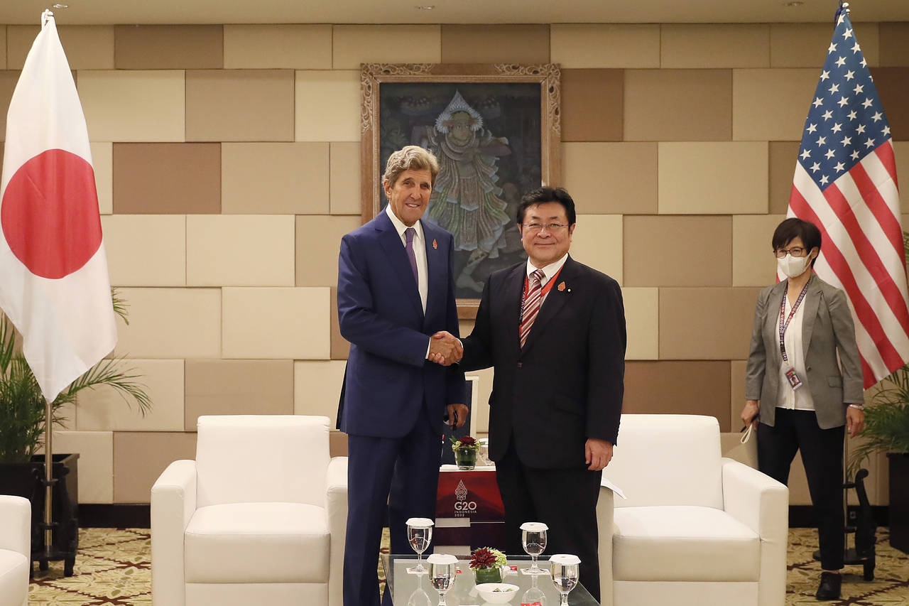 Japanese Environment Minister Akihiro Nishimura, right, shakes hand with U.S. Special Presidential ...