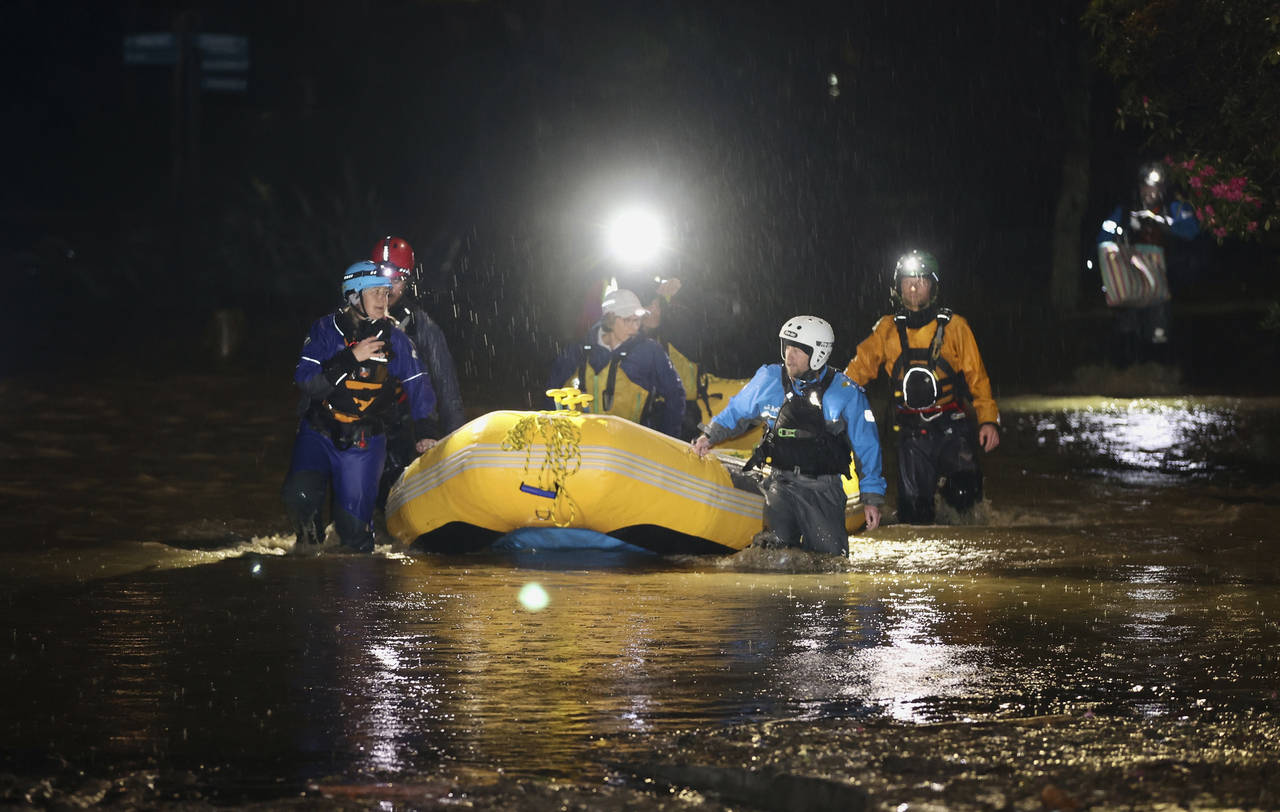 Emergency workers use an inflatable boat to rescue stranded residents in Nelson, New Zealand, Wedne...