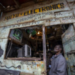 
              A man watches electoral news on a television in an electronics repair shop in the Kibera area of Nairobi, Kenya Thursday, Aug. 11, 2022. Kenyans are waiting for the results of a close presidential election in which the turnout was lower than usual. (AP Photo/Ben Curtis)
            