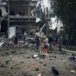 
              People stand in front of destroyed buildings after the Russian shelling in Mykolaiv, Ukraine, Wednesday, Aug. 3, 2022. According local media, supermarket, high-rise buildings and pharmacy were damaged. (AP Photo/Kostiantyn Liberov)
            