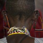 
              A woman wearing traditional Maasai jewellery lines up to vote at the Oltepesi Primary School, Kajiado County in Nairobi, Kenya, Tuesday Aug. 9, 2022. Kenyans are voting to choose between opposition leader Raila Odinga and Deputy President William Ruto to succeed President Uhuru Kenyatta after a decade in power. (AP Photo/Ben Curtis)
            
