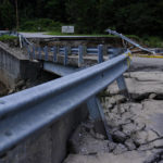 
              The road leading to a bridge above a creek cracks and breaks after massive flooding on Thursday, Aug. 4, 2022, in Chavies, Ky. (AP Photo/Brynn Anderson)
            