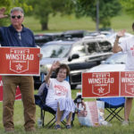 
              Kurt Winstead, left, a candidate in Tennessee's 5th Congressional District Republican primary, waves to people arriving at a voting location Thursday, Aug. 4, 2022, in Brentwood, Tenn. With Winstead are his mother, Wilma, and daughter, Bridget. (AP Photo/Mark Humphrey)
            