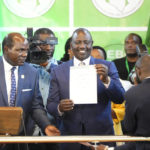 
              William Ruto, center, shows a certificate after the announcement of the results of the presidential race at the Centre in Bomas, Nairobi, Kenya, Monday, Aug. 15, 2022. After last-minute chaos that could foreshadow a court challenge, Kenya’s electoral commission chairman on Monday declared Deputy President William Ruto the winner of the close presidential election over five-time contender Raila Odinga. (AP Photo/Sayyid Abdul Azim)
            