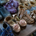 
              Children's shoes that have been donated to the nonprofit, SAMU First Response, await asylum seekers from Latin America and Haiti arriving on a bus sent to Washington from Arizona, Thursday, Aug. 11, 2022, at a church on Capitol Hill in Washington. (AP Photo/Jacquelyn Martin)
            