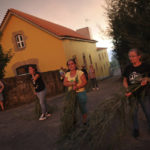 
              Workers of a retirement home, in the background, hold tree branches to fight an approaching wildfire in Gouveia, in the Serra da Estrela mountain range, in Portugal on Thursday, Aug. 18, 2022. Soon after firefighters arrived stopping the fire from reaching the buildings. (AP Photo/Joao Henriques)
            