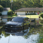 
              An SUV rests in flood waters in this northeast Jackson, Miss., neighborhood, Monday, Aug. 29, 2022. Flooding affected a number neighborhoods that are near the Pearl River. (AP Photo/Rogelio V. Solis)
            