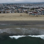 
              FILE - This aerial image taken with a drone, shows the closed beach after oil washed up in Newport Beach, Calif., on Oct. 7, 2021. A pipeline operator says it has reached a settlement with tour operators, fishermen and other businesses that sued after a crude oil spill off the Southern California coast last year. Amplify Energy says in a statement Thursday, Aug. 25, 2022, that claims have been settled in a class-action lawsuit filed by businesses affected by the October spill of about 25,000 gallons (94,600 liters) of crude into the Pacific Ocean. (AP Photo/Ringo H.W. Chiu, File)
            