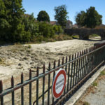 
              A sign on a fence near the dried-up river Tille says 'Swimming is Forbidden' in Lux, France, Tuesday Aug. 9, 2022. Burgundy, home to the source of the Seine River which runs through Paris, normally is a very green region. This year, grass turned yellow, depriving livestock from fresh food, and tractors send giant clouds of dust in the air as farmers work in their dry fields. (AP Photo/Nicholas Garriga)
            