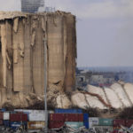 
              A collapsed portion, right, lies on the ground of the silos that damaged during the August 2020 massive explosion in the port, in Beirut, Lebanon, Tuesday, Aug. 23, 2022. The ruins of the Beirut Port silos' northern block that withstood a devastating port explosion two years ago has collapsed. The smoldering structure fell over on Tuesday morning into a cloud of dust, leaving the southern block standing next to a pile of charred ruins. (AP Photo/Hussein Malla)
            