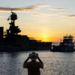 
              The sun rises behind the USS Texas as it is towed into the Houston Ship Channel in La Porte, Texas, Wednesday, Aug. 31, 2022. The ship, which fought in both world wars, is making the journey to a dry dock in Galveston, where it will undergo an extensive $35 million repair. (Brett Coomer/Houston Chronicle via AP)
            