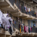 
              A woman hangs washing to dry on the balcony of an apartment block in the Kibera neighborhood of Nairobi, Kenya Sunday, Aug. 14, 2022. Kenyans attended regular church services on Sunday, at which many pastors preached a message of patience and peace, as the country continues to wait for the results of Tuesday's presidential election. (AP Photo/Ben Curtis)
            