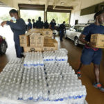 
              Firefighters and recruits for the Jackson, Miss., Fire Department carry cases of bottled water to residents vehicles, Aug. 18, 2022, as part of the city's response to longstanding water system problems. On Monday, Aug. 29, 2022, Mississippi Gov. Tate Reeves said he's declaring a state of emergency after excessive rainfall worsened problems in one of Jackson’s already troubled water-treatment plants. (AP Photo/Rogelio V. Solis)
            
