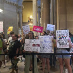 
              Abortion-rights protesters fill Indiana Statehouse corridors and cheer outside legislative chambers, Friday, Aug. 5, 2022, as lawmakers vote to concur on a near-total abortion ban, in Indianapolis. (AP Photo/Arleigh Rodgers)
            