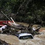 
              A truck is washed away by floodwaters in the Troublesome Creek near Main Street, in Hindman, Ky., Monday, Aug. 1, 2022. The creek has started to recede, leaving business owners in the town to start cleanup efforts. (Amanda Rossmann/Courier Journal via AP)
            