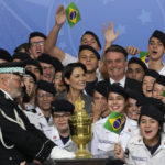 
              Brazil's President Jair Bolsonaro and his wife Michelle Bolsonaro, center, pose for photos with military cadets, next to the reliquary containing the heart of Brazil's former emperor Dom Pedro I, during a ceremony at the Planalto Presidential Palace in Brasilia, Brazil, Tuesday, Aug. 23, 2022. The heart arrived for display during the celebrations of Brazil's independence bicentennial on Sept. 7. (AP Photo/Eraldo Peres)
            