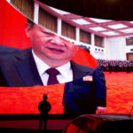 
              FILE - A child stands near a large screen showing photos of Chinese President Xi Jinping near a car park in Kashgar in western China's Xinjiang region on Dec. 3, 2018. China's discriminatory detention of Uyghurs and other mostly Muslim ethnic groups in the western region of Xinjiang may constitute crimes against humanity, the U.N. human rights office said in a long-awaited report Wednesday, Aug. 31, 2022, which cited "serious" rights violations and patterns of torture in recent years. (AP Photo/Ng Han Guan, File)
            