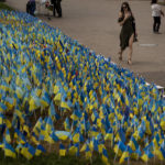 
              Ukrainian flags to honor soldiers killed fighting Russian troops, are placed in a garden in Kiev's Independence Square, Ukraine, Sunday, Aug. 28, 2022. (AP Photo/Emilio Morenatti)
            