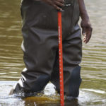 
              Hinds County Emergency Management Operations deputy director Tracy Funches, uses a special yardstick to check flood levels in a northeast Jackson, Miss., neighborhood, Monday, Aug. 29, 2022. Flooding affected a number of neighborhoods that are near the Pearl River. (AP Photo/Rogelio V. Solis)
            
