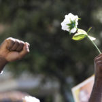 
              A demonstrators holds up a white rose during a protest to demand justice for Nigerian street vendor Alika Ogorchukwu in Civitanova Marche, Italy, Saturday, Aug. 6, 2022. The brutal killing of Ogorchukwu in broad daylight has sparked a debate in this well-to-do Adriatic beach community over whether the attack by an Italian man with a court-documented history of mental illness was racially motivated. (AP Photo/Antonio Calanni)
            