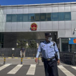 
              A policeman stands in front of the No. 1 Intermediate People's Court, where Zhou Xiaoxuan, a former intern at state broadcaster China Central Television, filing her appeal case against CCTV host Zhu Jun of groping and forcibly kissing her in 2014, in Beijing, Wednesday, Aug. 10, 2022. A Chinese court rejected an appeal Wednesday from a woman seeking an apology and damages in a high-profile case from the country's short-lived #MeToo movement. (AP Photo/Andy Wong)
            