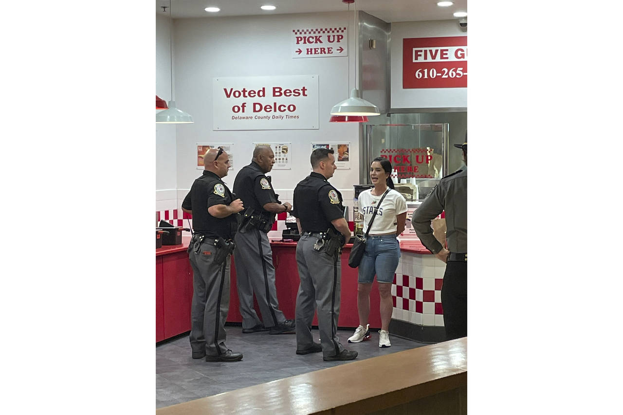 In this photo provided by Corey Cohen, a woman was handcuffed and taken into custody after pulling ...